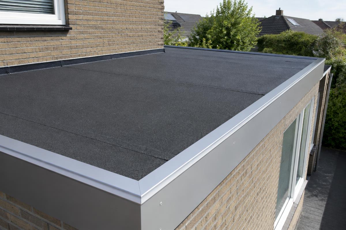 Nieuw aangelegd plat dak met bitumen en aluminium daktrim